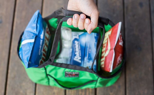 A person holding the handle of The Truck filled with chips, beer, and marshmallows.